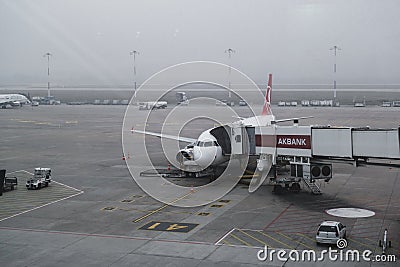 Airplane and airplane passenger boarding ramp in Izmir Adnan Menderes Airport. Editorial shot in Izmir Turkey Editorial Stock Photo