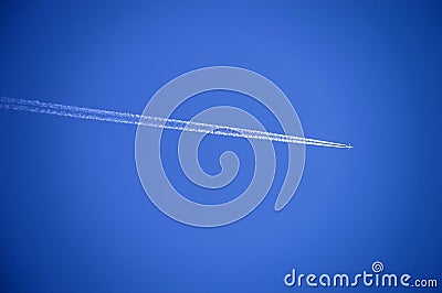 The airplane in the sky and the cluster of clouds left, the plane in the blue sky, and the cluster of clouds that it leaves. Stock Photo