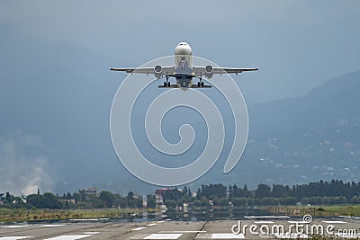 Airplane taking off from the airport, mountains on background. Transportation concept Stock Photo