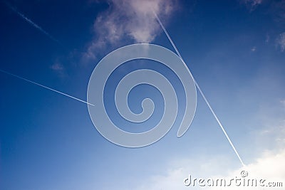 Airplane trails on blue sky Stock Photo