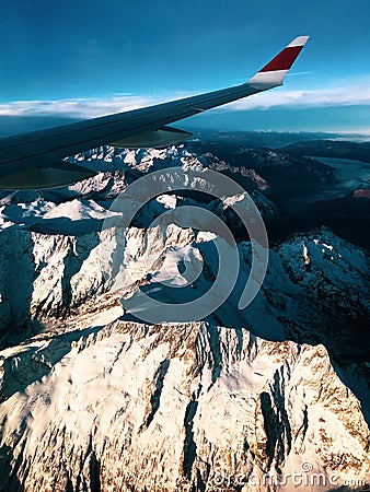 Airplane window view: airliner overflying the swiss-italian Alps Stock Photo