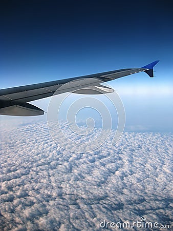 Airplane wing over blue sky with clouds view Stock Photo