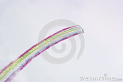 Airplanes on airshow with colorful bright trails of smoke against a blue sky, clouds. Aircraft, Airplane flying and Stock Photo