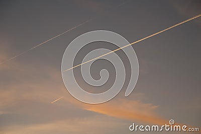 Airplanes and contrails of another airplanes at sunset. Stock Photo