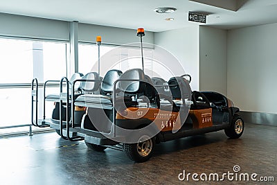 Airport battery powered vehicles for transporting passengers around the airport building. Modern airport service Editorial Stock Photo