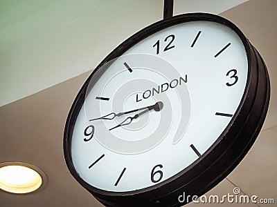 An airport clock showing London time zone Stock Photo