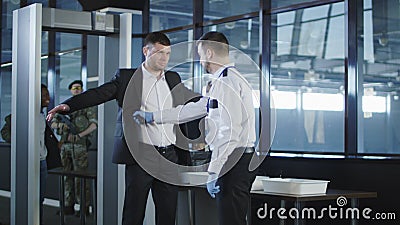 Security agent using a metal detector on a man Stock Photo