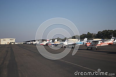 Airport view with Cessna airplanes lined up on the airfield, blue sky and trees background Editorial Stock Photo