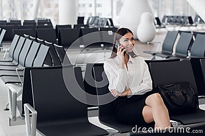 Airport woman on smart phone at gate waiting in terminal. Air travel concept with young casual business woman sitting Stock Photo