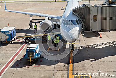 Airport workers a round white airplane in the airport before departure in Buenos aires Argentina Editorial Stock Photo