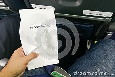 Airsick nauseous person holding the air sickness vomit bag Stock Photo