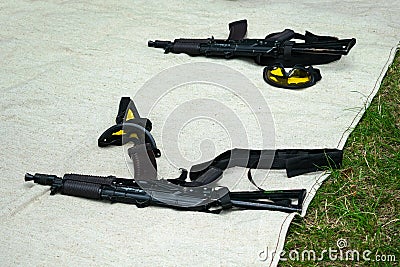 Airsoft automatic gun and yellow safety glasses lying on the fab Stock Photo