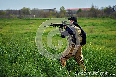 Airsoft player in military uniform aims at the enemy Stock Photo