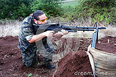 Airsoft soldier shooting with M60 Stock Photo