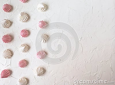 the airy meringue white and pink lies on a light Desk in rows and columns. Stock Photo