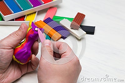 Airy plasticine mass for modeling colored super light plasticine on a white background. hands sculpt with plasticine Stock Photo