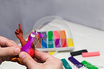 Airy plasticine mass for modeling colored super light plasticine on a white background. hands sculpt with plasticine Stock Photo