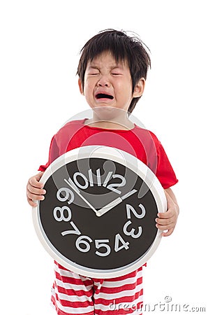 Aisan boy crying and holding clock Stock Photo