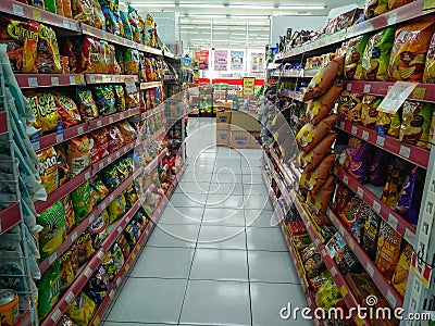 Aisle with various kinds of snacks on the shelves inside Minimarket Editorial Stock Photo