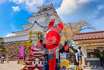 Japanese dresses a `Akabeko` mascot at Aizu-Wakamatsu Castle Editorial Stock Photo