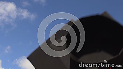 Akademikern caps flyg upp och ner i blå himmel, studenter som firar avläggande av examen stock video Akademikern caps flyg upp och ner i blå himmel, studenter som firar avläggande av examen stock video