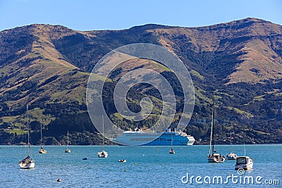 A cruise ship anchored against a mountainous background Stock Photo