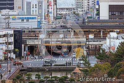 Akashi, Japan - December 29, 2022: Light traffic moves through downtown intersection as trains depart station overhead Editorial Stock Photo