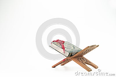 Al Quran and red tasbih or rosary beads over white background. Stock Photo