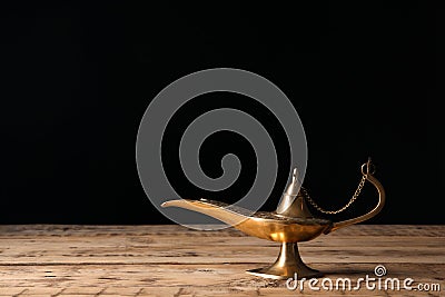 Aladdin lamp of wishes on wooden table black background Stock Photo