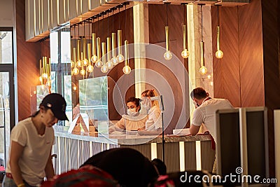 Alanya, Turkey - May 26: Masked caucasian women works at the hotel reception. Editorial Stock Photo