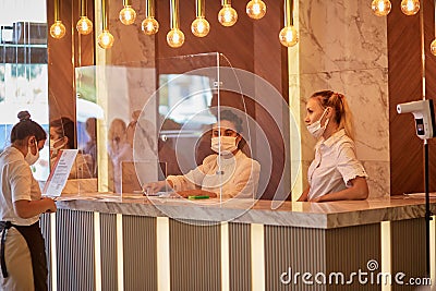 Alanya, Turkey - May 26: Masked caucasian women works at the hotel reception. Editorial Stock Photo