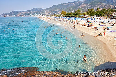 Alanya, Turkey - September 14, 2017: Tropical sea beach with swimming tourists on summer vacation resort. Editorial Stock Photo