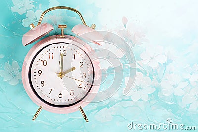 Alarm clock with cherry blossoms, switch to daylight saving time in spring, summer time changeover Stock Photo