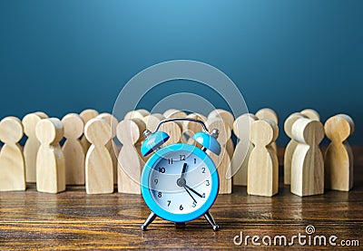 Alarm clock and a crowd of people. Time management. Hourly wages, strict work limits and break time. Planning and forecasting. Stock Photo