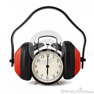 Alarm clock with ear defenders on. Stock Photo