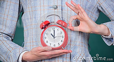 Alarm clock in female hands close up. Teachers attributes. Alarm clock in hands of teacher or educator classroom Stock Photo