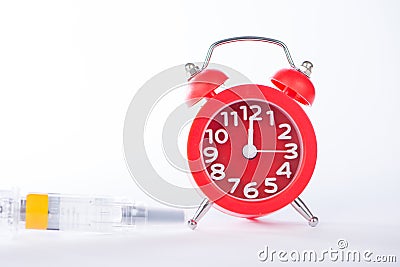 Alarm clock and injection syringe show medicine time Stock Photo