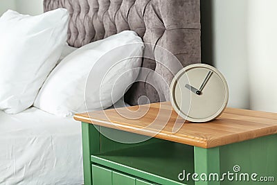 Alarm clock on nightstand in bedroom, space Stock Photo