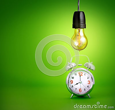 Alarm clock and with One antique Light bulb turn on, a symbol of Stock Photo