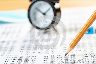 Alarm clock, optical form of standardized school test with bubble and black pencil, answer sheet, education concept Stock Photo