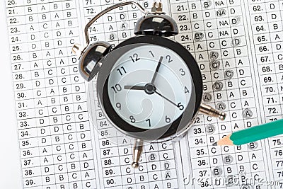 Alarm clock, optical form of standardized school test with bubble and black pencil, answer sheet, education concept Stock Photo