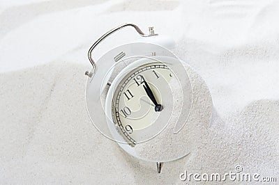 Alarm clock in sand on beach. Vacation time concept Stock Photo