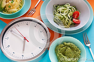 Alarm clock, Spiral Fresh Cucumber, Vegetable Marrow Spaghetti - Vegetarian, Diet Food, Vegetable Salad, Intermittent fasting Stock Photo