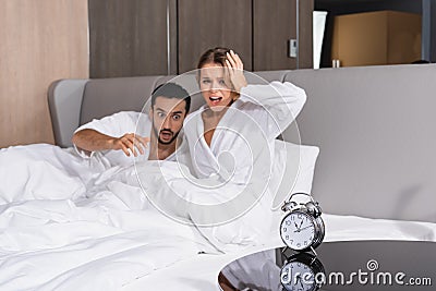 Alarm clock on table near excited Stock Photo