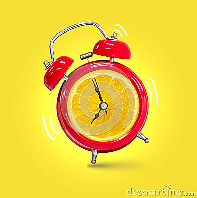 Alarm clock twin Bell-type red with fresh yellow lemon background Stock Photo