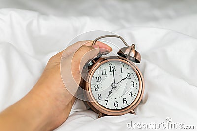 alarm clock on the white bed Stock Photo
