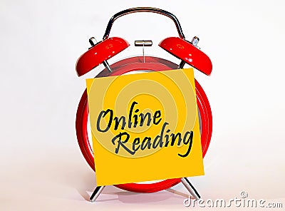 An alarm clock and a yellow note with text online reading. Stock Photo