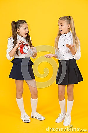 Alarm ringing. Time for lunch. School schedule. Schoolgirls and alarm clock. Children school pupils adorable formal Stock Photo