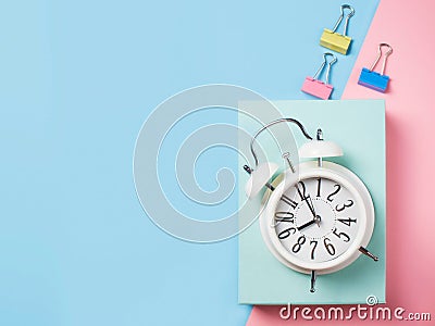 Alarm with supplies on color block background. Pastel minimalism Stock Photo