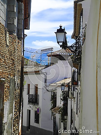 Albaicin, Old muslim quarter, district of Granada in Spain. Narrow street with white houses. Blue summer sky. Stock Photo